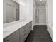 A full bathroom with double sinks, gray cabinets and a glass door walk-in shower at 130 Forrest Aly, Roswell, GA 30075
