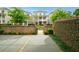 Charming exterior view featuring a landscaped yard, brick wall, and manicured shrubs at 130 Forrest Aly, Roswell, GA 30075