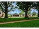 Beautiful green space with mature trees, sidewalks, and local businesses in the background at 130 Forrest Aly, Roswell, GA 30075