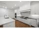 Bright kitchen boasts a large island with quartz countertop, stainless steel appliances and white cabinets at 130 Forrest Aly, Roswell, GA 30075