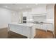 Modern kitchen features stainless steel appliances, white cabinetry, a large island and hardwood floors at 130 Forrest Aly, Roswell, GA 30075