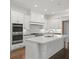 Gourmet kitchen with stainless steel appliances, white cabinets, large island, and ample counter space at 130 Forrest Aly, Roswell, GA 30075