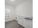 A laundry room with gray tile flooring, shaker cabinets, and quartz countertops at 130 Forrest Aly, Roswell, GA 30075