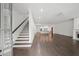Bright living area with hardwood floors, staircase, open to kitchen, and abundant natural light at 130 Forrest Aly, Roswell, GA 30075