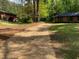 Long gravel driveway leading to a brick home surrounded by mature trees at 3080 Hogan Sw Rd, Atlanta, GA 30331