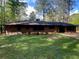 Charming brick ranch-style home with a lush green lawn and mature trees at 3080 Hogan Sw Rd, Atlanta, GA 30331