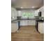 Bright kitchen features white cabinets, granite countertops, new appliances, and modern wood grain flooring at 3080 Hogan Sw Rd, Atlanta, GA 30331