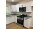 Bright kitchen features white cabinets, granite countertops, new appliances, and modern wood grain flooring at 3080 Hogan Sw Rd, Atlanta, GA 30331