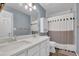 Modern bathroom features a double sink vanity and a shower-tub combo with stylish curtain at 5155 Amberden Hall Dr, Suwanee, GA 30024