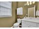 Bathroom with white cabinets, marble countertop, and window with blind providing natural light at 5155 Amberden Hall Dr, Suwanee, GA 30024