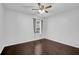 Simple bedroom with a dark floor, ceiling fan, and a window covered by a curtain at 5155 Amberden Hall Dr, Suwanee, GA 30024