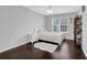 Cozy bedroom with hardwood floors, a bed, and a white rug, illuminated by natural light at 5155 Amberden Hall Dr, Suwanee, GA 30024