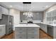 Updated kitchen with gray cabinets, quartz counters, an island with pendant lights, and stainless appliances at 5155 Amberden Hall Dr, Suwanee, GA 30024