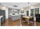 Modern kitchen features gray cabinets, stainless steel appliances, an island with seating, and hardwood flooring at 5155 Amberden Hall Dr, Suwanee, GA 30024