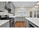 Updated kitchen featuring white countertops, stainless steel appliances, and gray cabinets for storage at 5155 Amberden Hall Dr, Suwanee, GA 30024