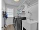 Efficient laundry room with washer, dryer, utility sink, and shelving for storage at 5155 Amberden Hall Dr, Suwanee, GA 30024