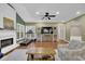 Open-concept living space includes a fireplace, a ceiling fan, a large TV with storage, and hardwood flooring at 5155 Amberden Hall Dr, Suwanee, GA 30024