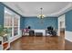 Bright living space with large windows, hardwood floors, and stylish decor; perfect for work or play at 5155 Amberden Hall Dr, Suwanee, GA 30024