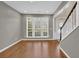 Open-concept living area with hardwood floors, a staircase, and abundant natural light at 5155 Amberden Hall Dr, Suwanee, GA 30024