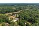 Expansive aerial view of estate home surrounded by lush greenery, pool, barn, and winding drive at 7180 Westray Rd, Cumming, GA 30028