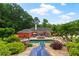 Stunning backyard with pool, slide, hot tub, patio, and lush landscaping at 7180 Westray Rd, Cumming, GA 30028