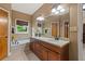 Bathroom with double sinks, vanity, and soaking tub at 7180 Westray Rd, Cumming, GA 30028