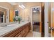 Double vanity bathroom featuring wood cabinets and a view into another room at 7180 Westray Rd, Cumming, GA 30028