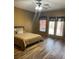 Bedroom featuring wood flooring, neutral walls, and private outdoor access at 7180 Westray Rd, Cumming, GA 30028