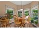 Bright breakfast nook with wood flooring, pendant lighting, and views of the lush backyard at 7180 Westray Rd, Cumming, GA 30028