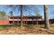 Expansive brick home featuring a wide porch, white railing, and large columns at 7180 Westray Rd, Cumming, GA 30028