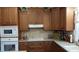 Well-lit kitchen featuring wooden cabinets, tiled backsplash, and modern appliances at 7180 Westray Rd, Cumming, GA 30028