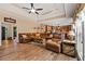 Spacious living room with hardwood floors, large leather sectional sofa, and tray ceilings at 7180 Westray Rd, Cumming, GA 30028