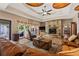Open living room showcases a large sofa, stone fireplace, and access to the outdoor pool at 7180 Westray Rd, Cumming, GA 30028