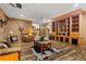 Cozy living room with hardwood floors, a leather sofa, and custom built-in shelves at 7180 Westray Rd, Cumming, GA 30028