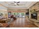 Cozy living room featuring a stone fireplace, tray ceilings, and expansive windows offering natural light at 7180 Westray Rd, Cumming, GA 30028
