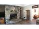 Cozy living room featuring a stone fireplace, wood floors, and tasteful decor at 7180 Westray Rd, Cumming, GA 30028