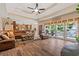 Comfortable living room featuring a ceiling fan, hardwood floors, and a view of the outdoor pool at 7180 Westray Rd, Cumming, GA 30028