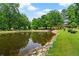 Scenic pond surrounded by lush greenery and trees, offering a peaceful setting at 7180 Westray Rd, Cumming, GA 30028