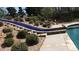Beautiful pool area features landscaping, stone and tile work, and mature trees at 7180 Westray Rd, Cumming, GA 30028