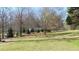 Green yard with mature trees and a pond providing a secluded setting for the home at 7180 Westray Rd, Cumming, GA 30028