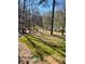 Tranquil view of the yard with a pond surrounded by mature trees, offering a peaceful outdoor retreat at 7180 Westray Rd, Cumming, GA 30028