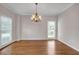 Dining room with wood floors, chandelier, neutral colors, and natural light from two windows at 1665 Little Lisa Ln, Snellville, GA 30078