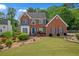 Charming red brick two-story home with manicured lawn and blue shutters and a blue front door at 1665 Little Lisa Ln, Snellville, GA 30078