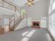 Living room with high ceilings, brick fireplace, large windows, and staircase at 1665 Little Lisa Ln, Snellville, GA 30078