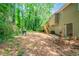 View of the back of the house featuring a deck and stairs leading to the yard, surrounded by lush trees at 2132 Sara Ashley Way, Lithonia, GA 30058