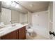 Bathroom with a vanity, toilet, and a tub with a white tile surround at 2132 Sara Ashley Way, Lithonia, GA 30058