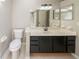 Well-lit bathroom featuring a dark vanity with a mirror and standard toilet at 2132 Sara Ashley Way, Lithonia, GA 30058