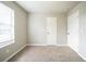 Well-lit bedroom with neutral carpeting, a window, and two doors at 2132 Sara Ashley Way, Lithonia, GA 30058