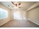 This bedroom includes neutral paint, carpet flooring, a ceiling fan, a double door closet, and a window at 2132 Sara Ashley Way, Lithonia, GA 30058