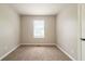Neutral carpeted bedroom features a window and a door at 2132 Sara Ashley Way, Lithonia, GA 30058